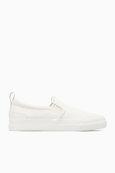 These slip-on trainers are an easy option for summer dressing – they'll go with all your casual outfits but will work equally well to pare back tailoring, too. Crafted from cotton-canvas with leather detailing, they come in versatile white and have chunky rubber soles and elasticated inserts for comfort. The leather pull tab at the back makes them easy to slip on and off. Leather binding and panellingRecycled cotton is made by converting both pre- and post-consumer fabric into fibres that are th Sporty Leather Slip-ons With Vulcanized Sole, White Sporty Slip-ons With Rubber Sole, Sporty White Slip-ons With Rubber Sole, Low-top Slip-on Sneakers With Rubber Waffle Outsoles, Sporty Slip-on Sneakers With Contrast Sole For Everyday, Sporty Slip-on Sneakers With Contrast Sole, Sporty Everyday Slip-on Sneakers With Contrast Sole, Casual White Slip-ons With Contrast Sole, Canvas Slip-on Sneakers With Contrast Sole