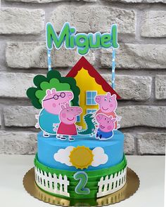 a birthday cake with pepo and george the pig on it's top tier