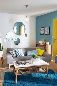 a living room filled with furniture and yellow doors on the wall behind it is a blue rug