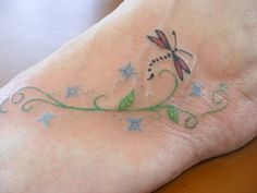 a small tattoo on the foot of a person's foot with stars and a dragon