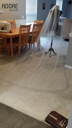 a room with a table, chairs and a veil hanging from the ceiling