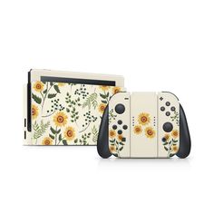 two nintendo wii game controllers with sunflowers and leaves on the sides, one is white