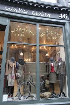 an old fashion store front with mannequins and suits in the window display