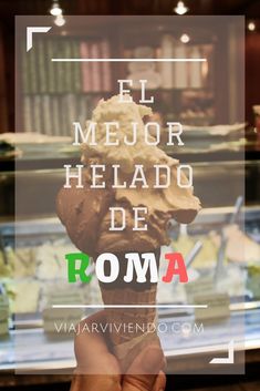 a person holding up a small statue in front of a glass case with the words, el mejor helado de roma