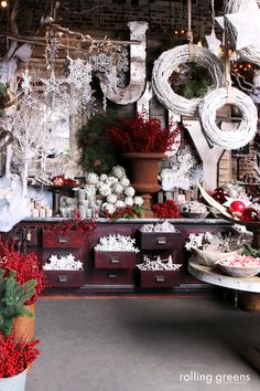 a christmas display in a store with ornaments and decorations on the wall, including wreaths