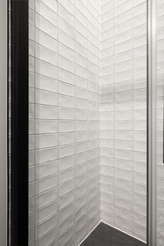 a white tiled shower stall in a bathroom