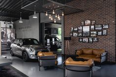 the interior of a car showroom with leather furniture and pictures on the wall above