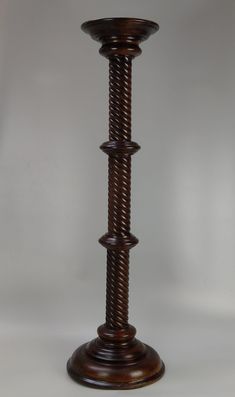 a tall wooden candle holder on a white background