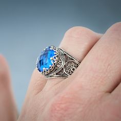 Dive into the realm of royalty with our meticulously handcrafted filigree art 925 sterling silver crown ring, beautifully accented with a 12mm faceted round-cut gemstone. Choose from the serene hues of Aqua Blue Chalcedony, the delicate tones of Pink Chalcedony, the vibrant Green Agate, the tranquil Blue Quartz, or the fiery Ruby Corundum. Each gemstone enhances this extraordinary piece, adding a unique touch of brilliance. Expertly crafted with intricate detailing, this majestic crown ring emanates an air of elegance and regality, setting it apart as a stunning piece of jewelry. Whether it's an anniversary, birthday, Christmas, Thanksgiving, Mother's Day, Valentine's Day, or any other significant event, this ring makes for the perfect heartfelt gift. Elevate your loved one's style and con Art Crown, Silver Crown Ring, Tranquil Blue, Pink Chalcedony, Silver Crown, Crown Design, Aqua Chalcedony, Crown Ring, Sterling Silver Filigree