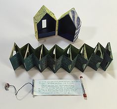 an origami house and its contents are on the table