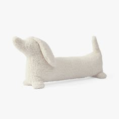 a white stuffed dog laying on its side