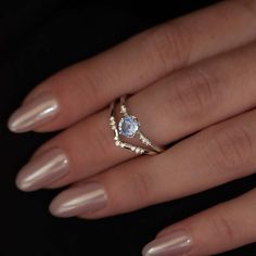 a woman's hand with a ring on it and a diamond in the middle