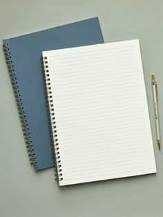 two notebooks next to each other with a pen resting on top of one book