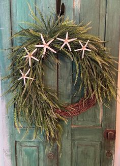 a wreath with starfishs is hanging on a door