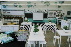 a room filled with tables and chairs next to each other in front of a whiteboard