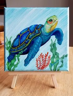 an acrylic painting of a sea turtle on a wooden easel with corals