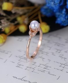 a pearl ring sitting on top of a piece of paper