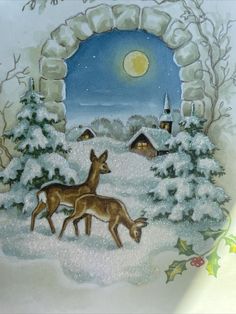 two deer are standing in the snow by a stone arch with a full moon behind them