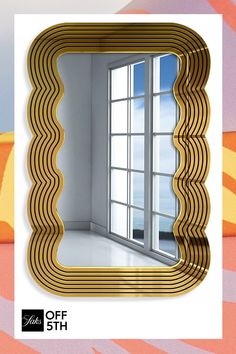 a mirror that is on the wall in front of a window with an artistic design