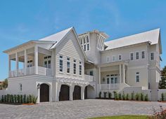 a large white house with lots of windows and balconies on the front porch