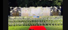 an outdoor ceremony setup with flowers and white fenced in area for the bride to sit down