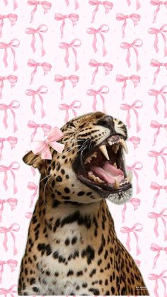 a leopard with its mouth open and pink bows on it's head