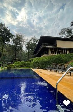 an empty swimming pool in front of a large house