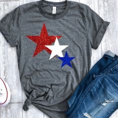 a t - shirt with red, white and blue stars painted on it next to jeans