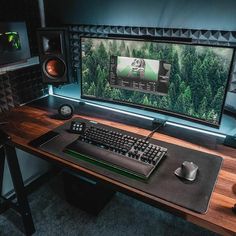 a desk with a keyboard, mouse and speakers on it in front of a computer monitor