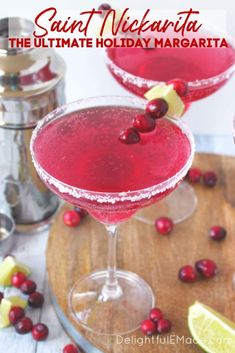 two glasses filled with cranberry margarita on top of a wooden table