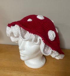 a crocheted hat with white polka dots on it