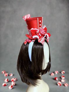 Peppermint Nutcracker Top Hat Add some fun to your Nutcracker shoots with the Peppermint Nutcracker Top Hat by The Head Mistress. A red satin top hat embellished with sweet peppermint accents, peppermint candy bow and candy striped ribbon makes this top hat a must-have sweet addition to your candy nutcracker photo shoots! This top hat is fixed to a headband and fits all ages. Premium Quality: Crafted from the finest materials for durability. Exclusive Design: Stand out with its unique and eye-ca Nutcracker Hat Headband, Peppermint Nutcracker, Candy Nutcracker, Red Satin Top, Fabric Photography, Design Stand, Striped Ribbon, How To Make Ribbon, Peppermint Candy