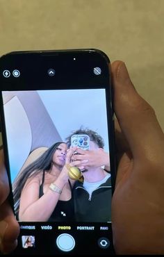 a person holding up a cell phone to take a selfie with the image on it