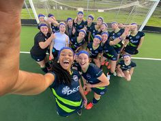 a group of young women standing on top of a soccer field holding up their hands