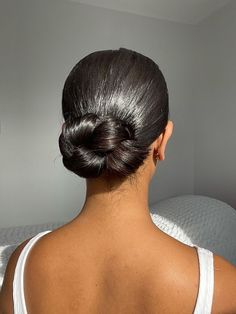 the back of a woman's head, with her hair in a low bun