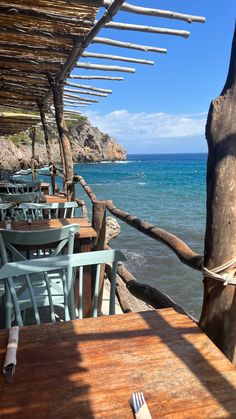 an outdoor dining area with tables and chairs overlooking the ocean