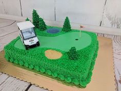 a cake with a golf course on it and a car in the middle is made out of green frosting