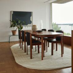 a dining room table with chairs and a rug