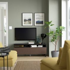 a living room filled with furniture and a flat screen tv on top of a wooden entertainment center