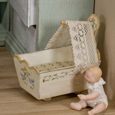 a small doll sitting next to a wooden box with a net on it's back