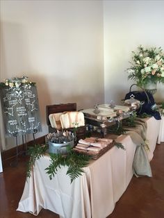 the table is set up for a wedding reception with flowers and desserts on it