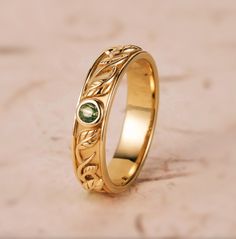 a gold ring with green stones on it