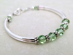 This birthstone bracelet can be personalized and gifted to your special someone. The recipient will most certainly feel special receiving this unique gift! All birthstone colors are available from the dropdown menu at checkout. OR, message me with a variety of colors to create a mother's bracelet. ~ peridot 6mm swarovski crystals ~ antiqued silver pewter spacers ~ silver plated tube bead bangles and lobster claw Click here to return to my shop's homepage: https://www.etsy.com/shop/beadedjewelryf Stackable Jewelry For May Birthstone Gift, Stackable May Birthstone Jewelry As Gift, Stackable May Birthstone Jewelry Gift, Nickel-free Crystal Bangle Bracelet For Gift, Silver Crystal Bracelet For Mother's Day, Green Birthstone Bracelets For Anniversary, Green Birthstone Bracelet For Anniversary, Mother's Day Silver Crystal Bracelet, Silver Bracelets With May Birthstone