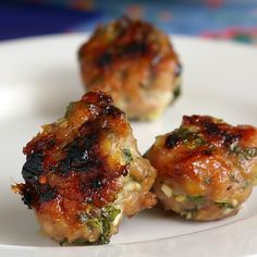 three pieces of meat sitting on top of a white plate