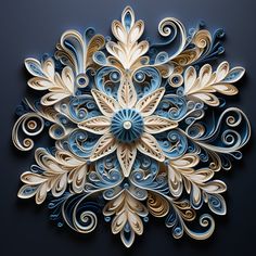 an intricately designed paper art piece on a black surface with blue and white swirls