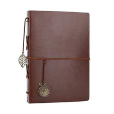 a brown leather journal with a leaf charm