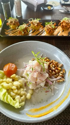 a white plate topped with lots of food on top of a table