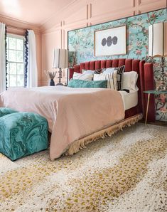 a bedroom with pink walls, blue and white bedding and floral wallpaper on the walls