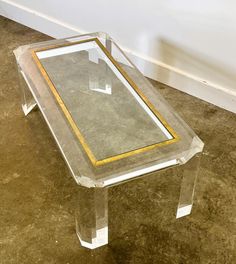 a glass and gold coffee table on the ground