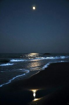 the moon shines brightly in the dark night sky over the ocean with waves crashing on it